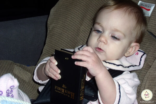 toddler carrying her Bible to church